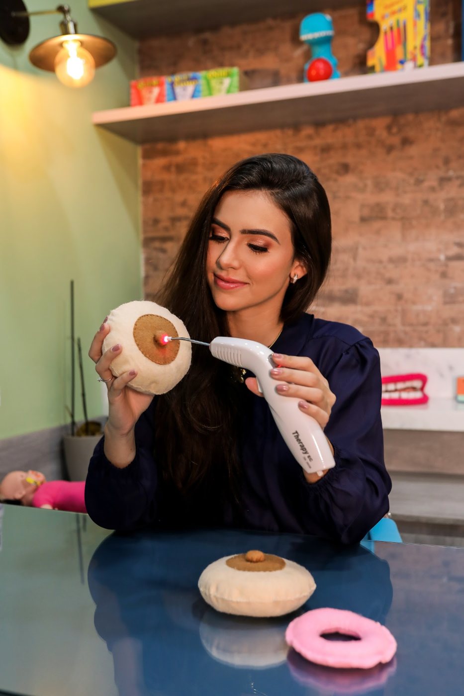 Alice Guedes no consultório demonstrando um recurso terapêutico em um modelo didático